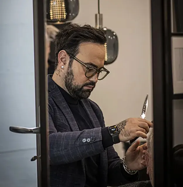 Homme barbu à lunettes coupant des cheveux avec des ciseaux à Blois dans le Loir-et-Cher 41