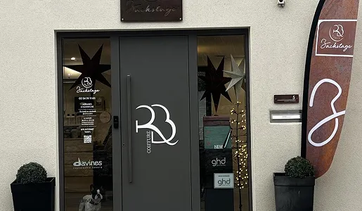 Façade d'un salon de coiffure nommé Backstage avec un drapeau rouille et un logo RB Coiffure à Blois dans le Loir-et-Cher 41