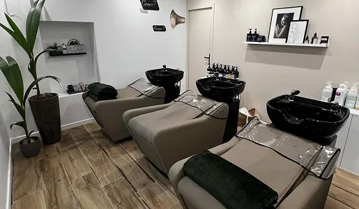 Trois chaises de salon de coiffure avec lavabos noirs, sur plancher en bois à Blois dans le Loir-et-Cher 41