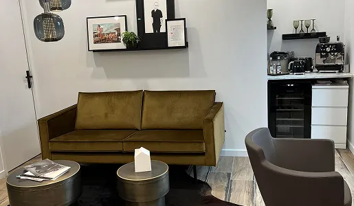 Canapé vert olive, table basse, art mural, mini-bar dans un salon moderne à Blois dans le Loir-et-Cher 41