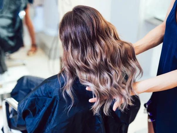 Une femme se fait coiffer avec des cheveux ondulés et un balayage chez le coiffeur à Blois dans le Loir-et-Cher 41